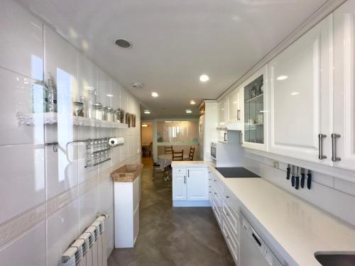 een keuken met witte kasten en een aanrechtblad bij Golf Apartment in Majadahonda