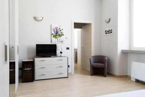 a living room with a tv on a dresser and a chair at La Viscontina in Somma Lombardo