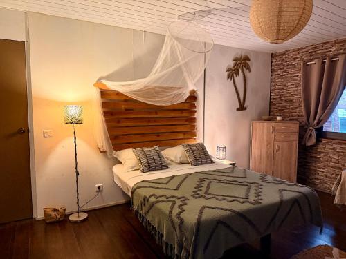 a bedroom with a large bed with a canopy at Faaora Lodge, little paradise Moorea in Haapiti