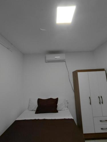 a white room with a bed and a mirror at J&m hospedagem in Marau