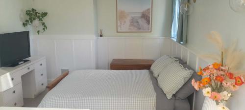 a bedroom with a bed and a tv and flowers at Green on Queen in Richmond
