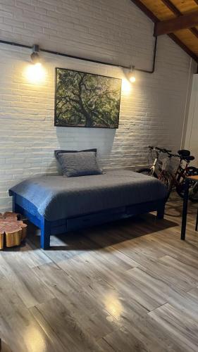 a bed in a room with a brick wall at Espaço RAVI 1 in Monte Verde