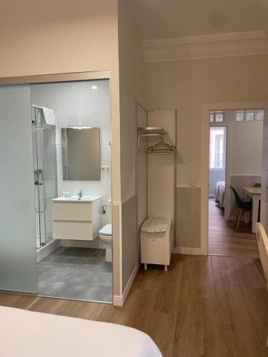a bathroom with a sink and a toilet and a mirror at Apartamentos Mayor Centro in Madrid