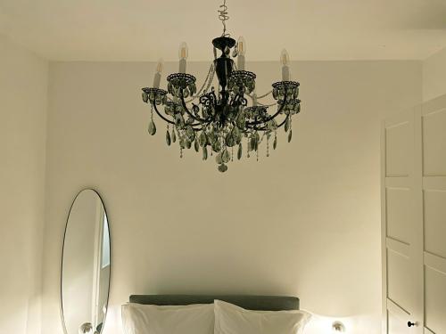 een kroonluchter boven een bed in een kamer bij Dimora minima in Empoli