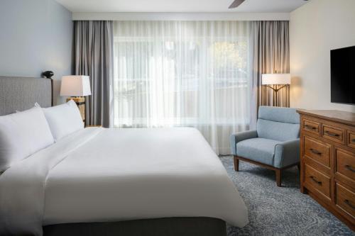 a bedroom with a bed and a chair and a television at Marriott's StreamSide Evergreen at Vail in Vail