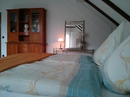 a large bed in a room with a mirror at Ostsee in Papenburg