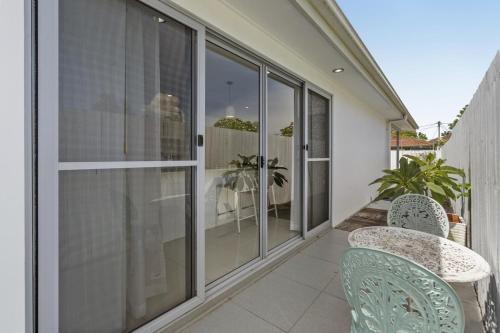 a balcony with glass doors and two chairs at Spacious 4-Bed House with Secure Parking in Brisbane