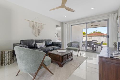 a living room with a couch and a table at Spacious 4-Bed House with Secure Parking in Brisbane