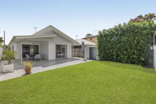 a house with a green lawn in front of it at Spacious 4-Bed House with Secure Parking in Brisbane