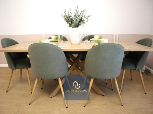 een houten tafel met vier stoelen en een vaas erop bij Chalfont Haven 