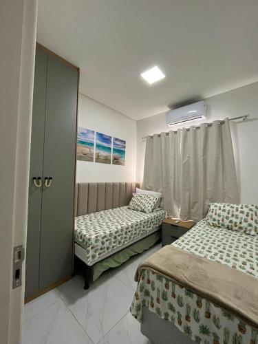 a bedroom with two beds and a window at Casa com Piscina em Tamandaré in Tamandaré