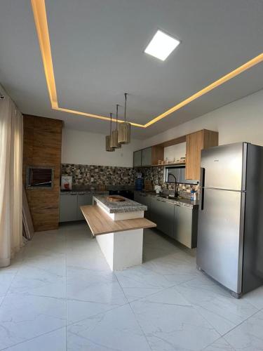 a kitchen with a refrigerator and a table in it at Casa com Piscina em Tamandaré in Tamandaré