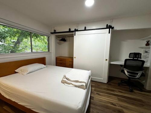een slaapkamer met een bed, een bureau en een raam bij Ensuite Private Room in Austin