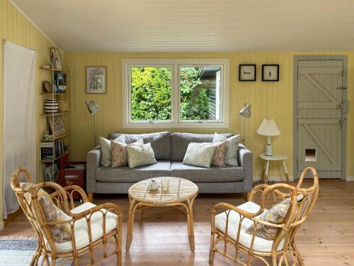 a living room with a couch and chairs and a table at Summerhouse Close To Nature And Beach in Rørvig