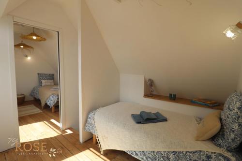 une petite chambre avec un lit et un miroir dans l'établissement Les Gites de Mael et Rose, à Plougasnou