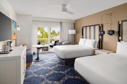 a hotel room with two beds and a desk at DoubleTree by Hilton Grand Key Resort in Key West