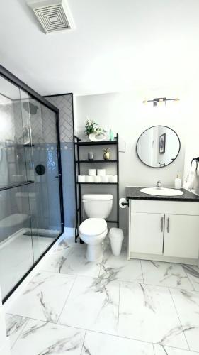 a bathroom with a toilet and a sink and a shower at Cozy boho downtown apartment in Calgary