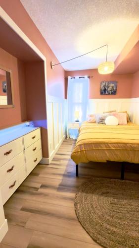 a bedroom with a bed and a dresser in it at Cozy boho downtown apartment in Calgary