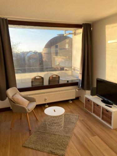 a living room with a large window with a view at Über den Dächern von Offenbach in Offenbach