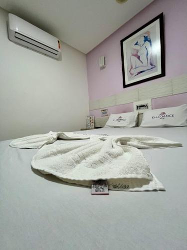 ein Schlafzimmer mit einem Bett mit einer weißen Decke in der Unterkunft Hotel Ellegance in Salvador