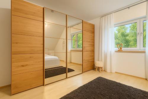 ein Schlafzimmer mit einem großen Holzschrank mit einem Bett darin in der Unterkunft Ferienwohnung Meinerzhagen in Meinerzhagen