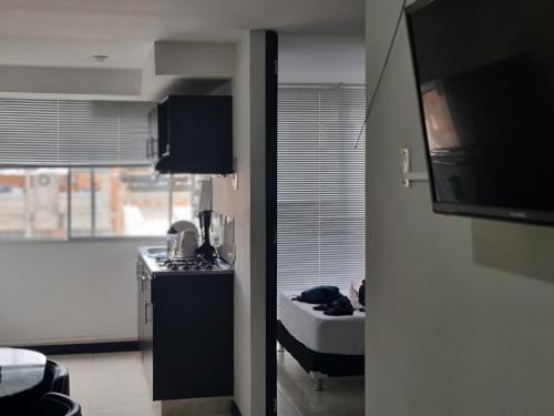 een kamer met een keuken en een bed in een kamer bij Apartamento Faunaventura cerca Parque del Café con piscina in Montenegro