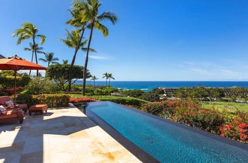 a swimming pool with the ocean in the background at Luxury Oceanview Villa with Infinity Pool in Hapuna Beach