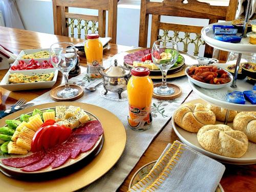 a table with plates of food and glasses of orange juice at Carpathia Magic -adults only in Peştera