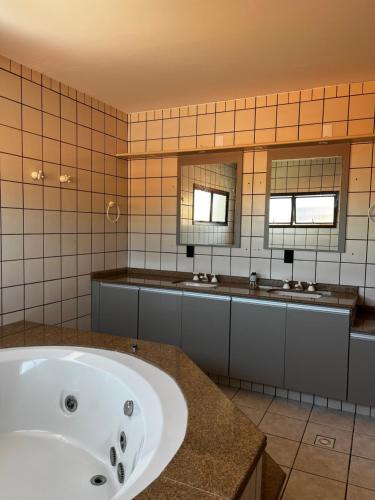 a large bathroom with a tub and two sinks at A casa do sonho in Palhoça