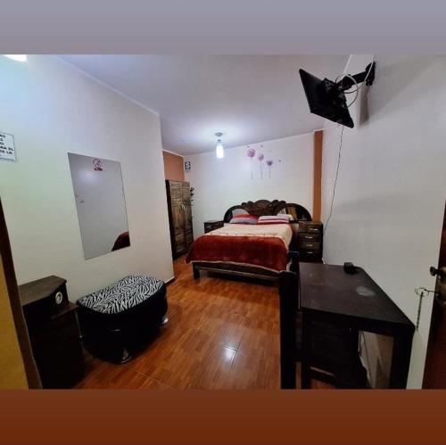 a bedroom with a bed and a table and a desk at Hospedaje secretos in Huancayo