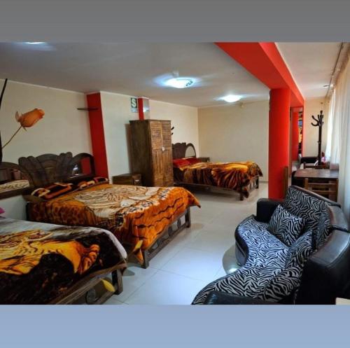 a room with two beds and a couch and chairs at Hospedaje secretos in Huancayo
