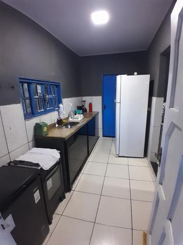 a kitchen with a refrigerator and a sink in it at Cantinho do sossego in Macaé