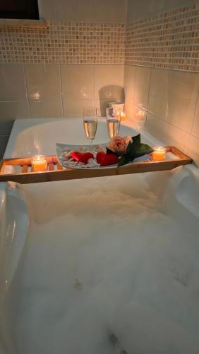 een dienblad met kaarsen en twee glazen op een bad bij Casa Adelaide - A stone's throw from Rome in Gavignano