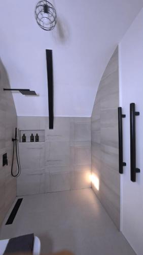 a white bathroom with a shower and a light at Kubotique Beachfront Staycation in El Nido