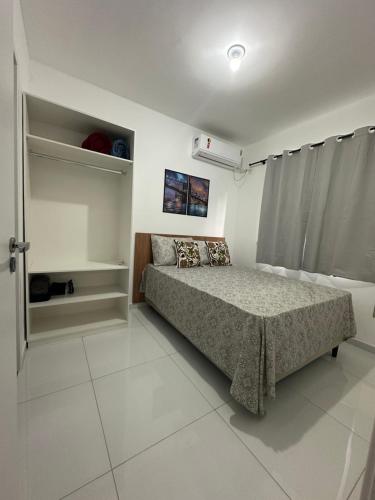 ein kleines Schlafzimmer mit einem Bett und einem Fenster in der Unterkunft Apartamento 403 no Calhau in São Luís