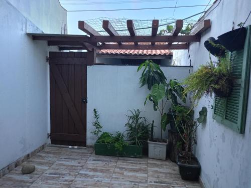 a wooden door with plants on the side of a building at Moinho dos ventos in São Pedro da Aldeia