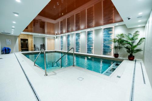 een zwembad in een grote kamer met een groot raam bij Résidence Domitys Les Belles Lettres centre ville face à la Gare 20 mn de Paris in Herblay