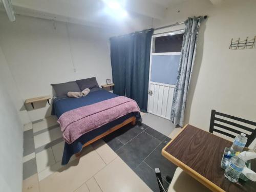 a small bedroom with a bed and a table at Hostal Casa Gavilán
