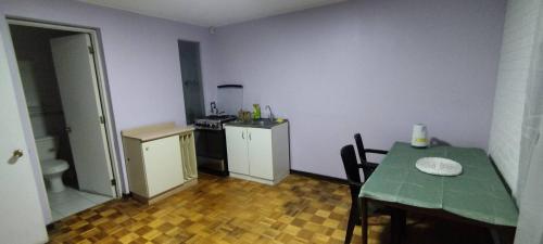 een kleine keuken met een tafel en een groene tafel en een tafel en een keuken bij Hostal Escondido in La Serena