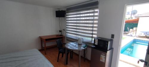 een kamer met een bed en een tafel met een klein tafeltje sidx sidx sidx bij Hostal Escondido in La Serena