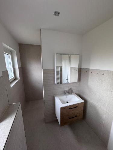 a white bathroom with a sink and a mirror at Ferienhaus am Seeburgersee 100 Meter zum Wasser in Niederdorla