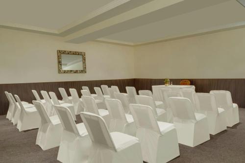 a room filled with white chairs and a table at The Fern Bambora Fort Udaipur, Bambora, Series by Marriott in Udaipur