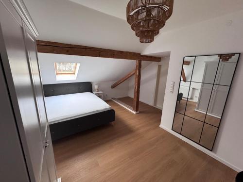 a small bedroom with a bed and a mirror at Ferienhaus am Seeburgersee 100 Meter zum Wasser in Niederdorla