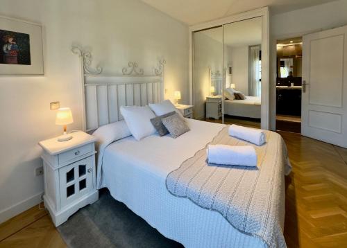 een slaapkamer met een groot wit bed en een spiegel bij Golf Apartment in Majadahonda