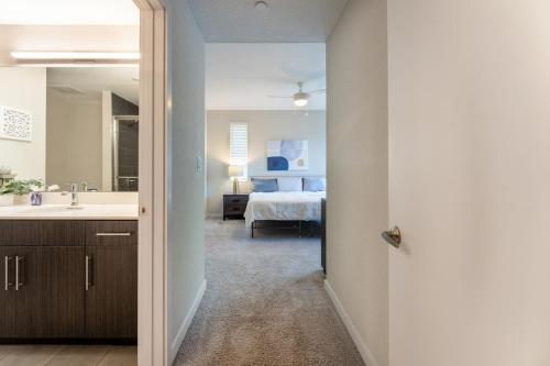 a bathroom with a sink and a bedroom with a bed at Spacious 3BR | Pool, Gym, Near Beach & Speedway in Daytona Beach