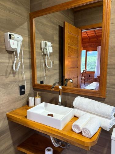 a bathroom with a sink and a mirror at Recanto João de barro in Visconde De Maua