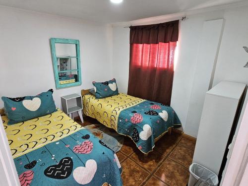 een slaapkamer met twee bedden en een spiegel bij MatSofy_Apartamento in Santiago