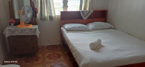 une petite chambre avec un lit avec un chapeau dessus dans l'établissement VureVure Homestay, à Mbouma