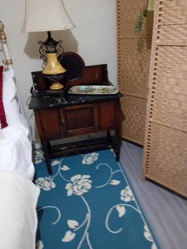 a bedroom with a table with a lamp on it at Owls Roost in Stowmarket