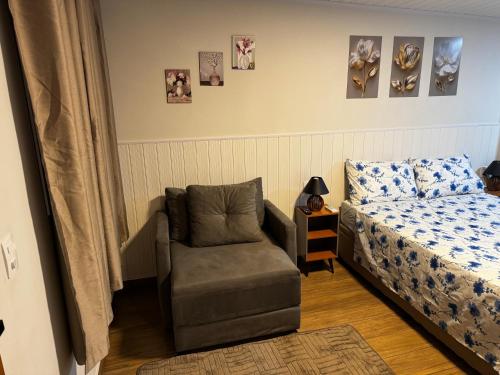 una camera con un letto e una sedia accanto a un letto di Vivaê Studio a Vila Velha